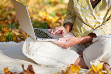 seniorin mit laptop im herbst