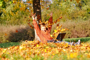 Boy under tree with notebook in autumn - 26756903