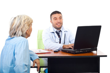 Doctor using laptop while converse with patient