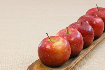 Five crisp red apples in a row