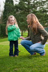 Fototapeta premium Smiling girl holding mother's hand at the park