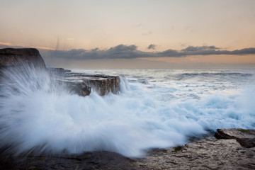 wave splash with rock cliff in background