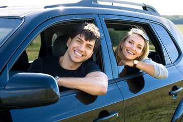 happy young couple driving the car