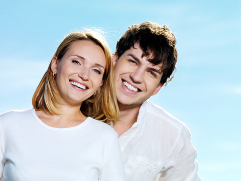 beautiful faces of couple on blue sky background