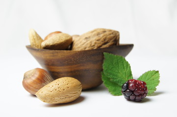 Nüsse in Holzschale mit Brombeere