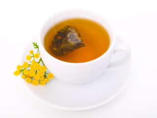white cup of black tea with tansy plant