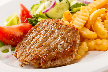 Grilled meat, French fries and vegetables
