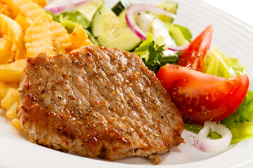 Grilled meat, French fries and vegetables