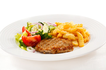 Grilled meat, French fries and vegetables