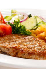 Grilled meat, French fries and vegetables