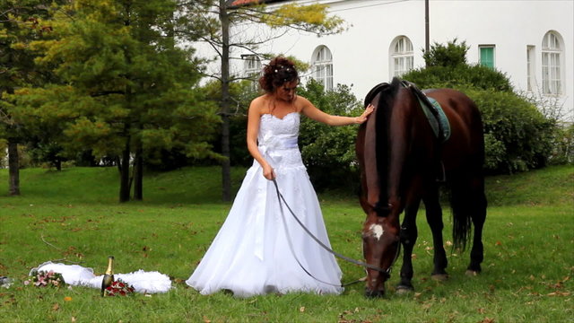 Beautiful bride and a horse walking in the park