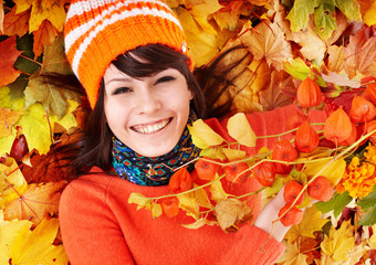 Young woman in autumn orange leaves.