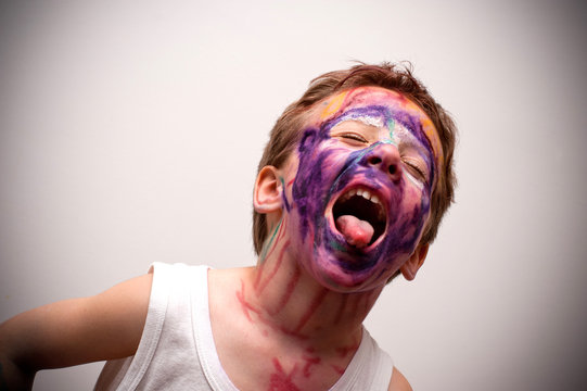 bambino con viso mascherato e linguaccia