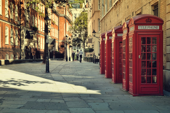 Fototapeta Street with traditional red Phone Boxes, London.