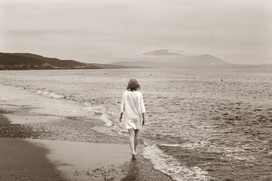 Young Caucasian girl walking at beach