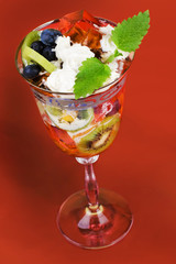 Fruit dessert with jelly on red background