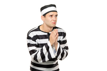 A sad prisoner with both hands clasp in begging gesture