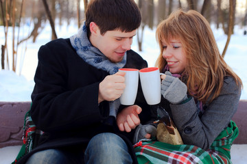 young beloved couple warming themselves in the winter park