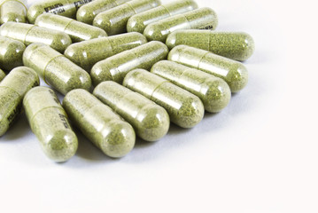green herbal medicine capsule isolated on white background