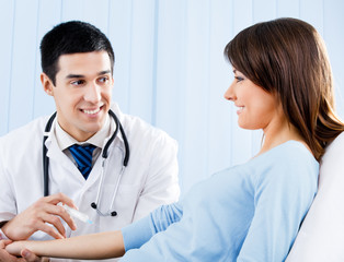 Doctor giving an injection to female patient