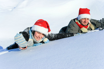 Caucasian woman and man laying on the snow