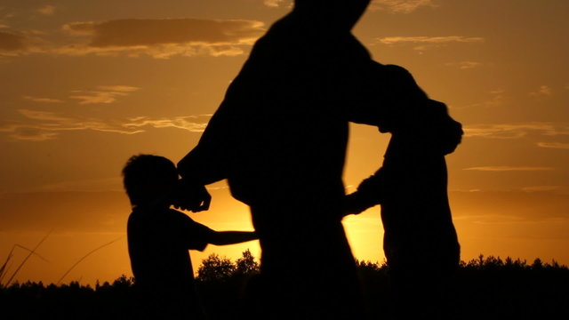 Happy family. A sunset. Silhouettes.