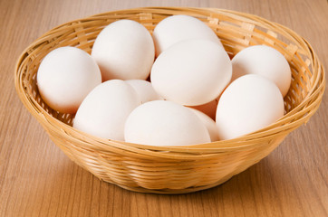 Many white eggs on the wooden table