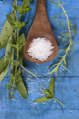 sea salt with herbs in a wooden spoon