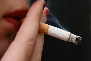 A woman holding a cigarette to her lips