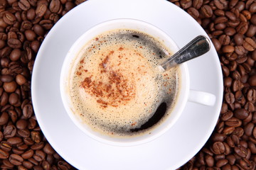 Cup of coffee with cinnamon, coffee beans and a spoon