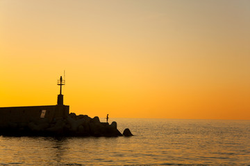 Silhouette Of Fisherman At Sunset