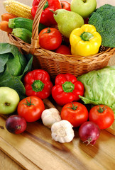 Composition with vegetables and wicker basket on kitchen table