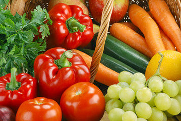 Composition with basket and vegetables on kitchen table