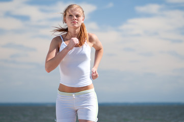 Sport woman running on beach