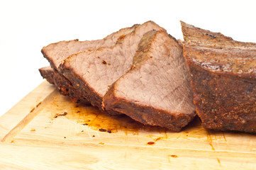 cooked roastbeef on a wooden board isolated