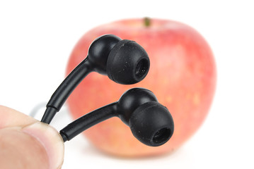 Apple with earphone on white background