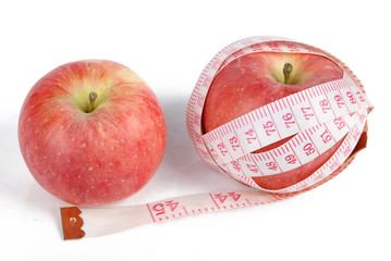 Apple and measuring tape on white background
