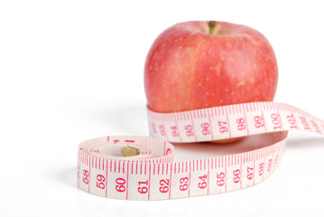 Apple and measuring tape on white background