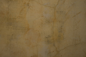 Sandy pale grey cracked plaster wall
