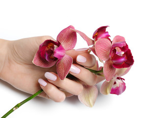 Beautiful hand with perfect nail pink manicure and purple orchid