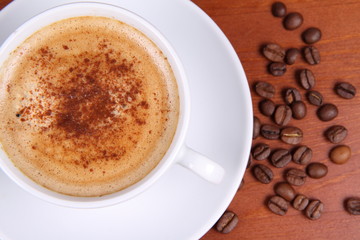 Cup of coffee sprinkled with cinnamon and some coffee beans