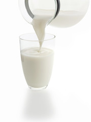 pouring a glass of milk (isolated on white background)
