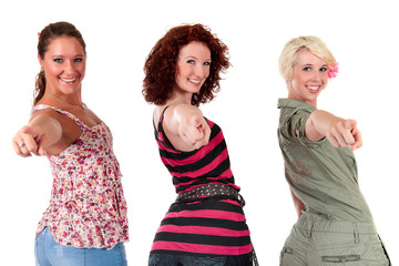 Three attractive young women pointing