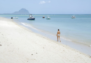 Topless woman walking on the beach