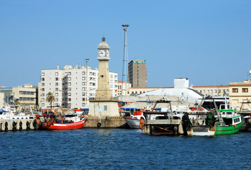 fishing ships and tower with hours per port of barcelona;  Port