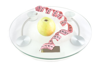 Scale, tape and green apple