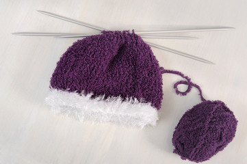 winter concept : purple bonnet with knitting needles