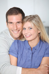 Smiling couple standing in home kitchen