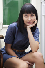 Obraz premium portrait of young brunette woman sitting on chair