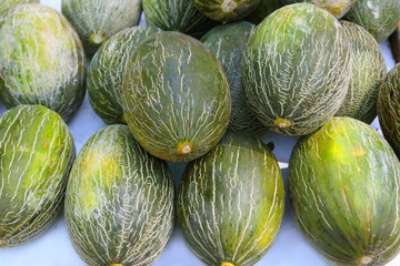 Piel de Sapo Santa Claus melon stacked rows fruit